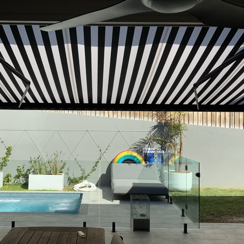 black and white stripe Folding Arm Awning over pool with alfresco