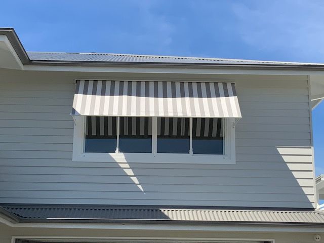 Heavy Duty Robusta Pivot arm awning with Over-Roll Hood grey & white striped solution dyed acrylic fabric fabric